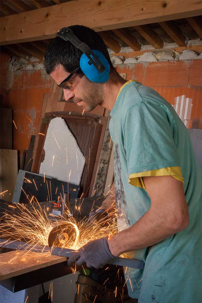 Homme qui travaille le métal avec une paire de lunette de protection et casque anti bruit